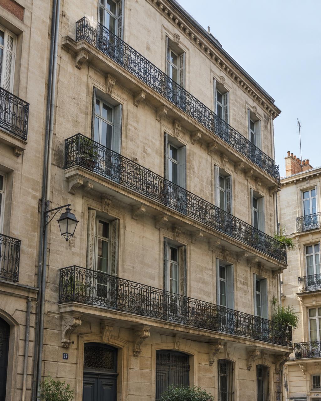 Immeuble ancien en pierre de taille avec balcons en fer forgé